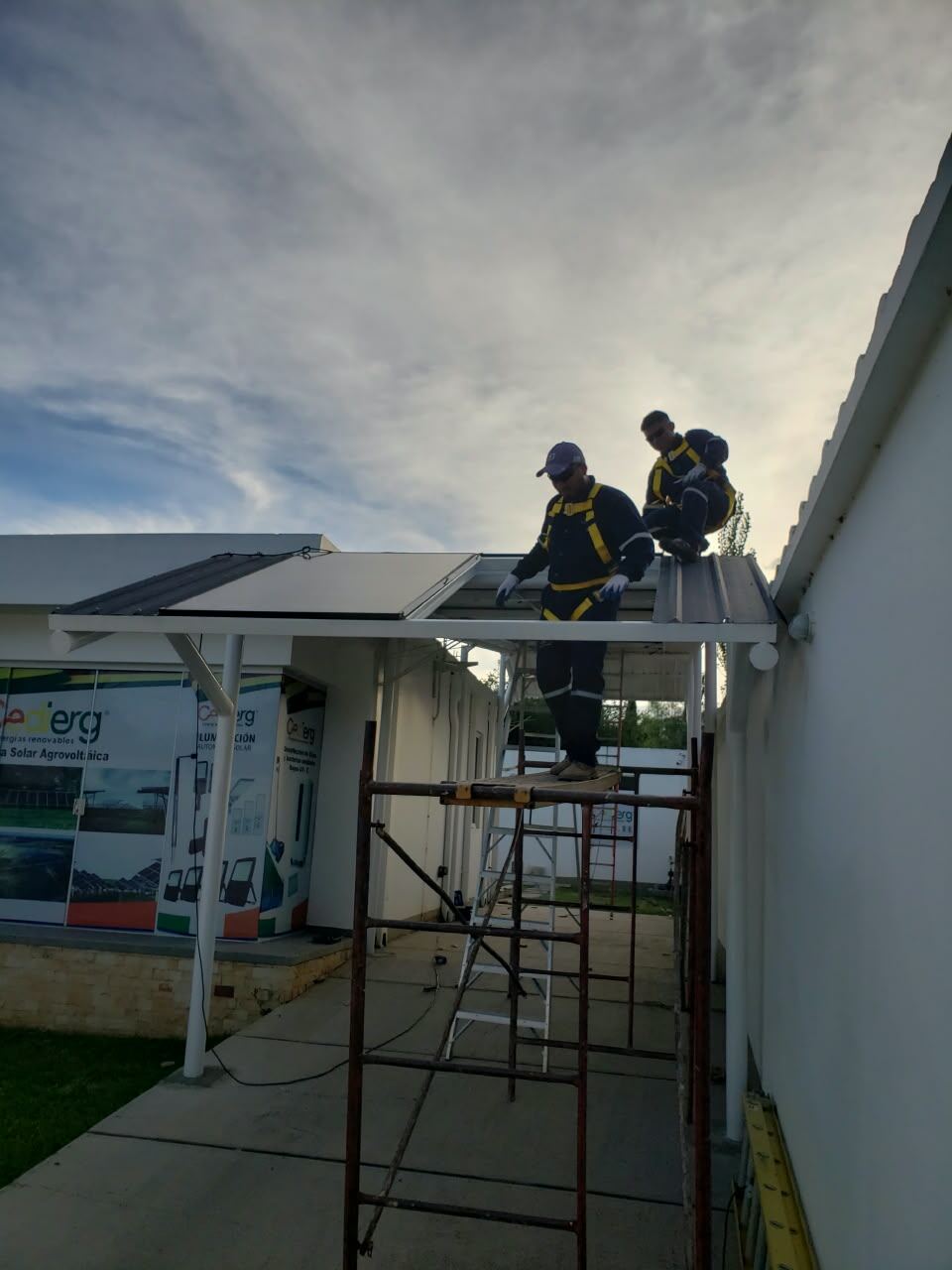 Técnicos de CEDIERG montando paneles sobre la cochera de la oficina