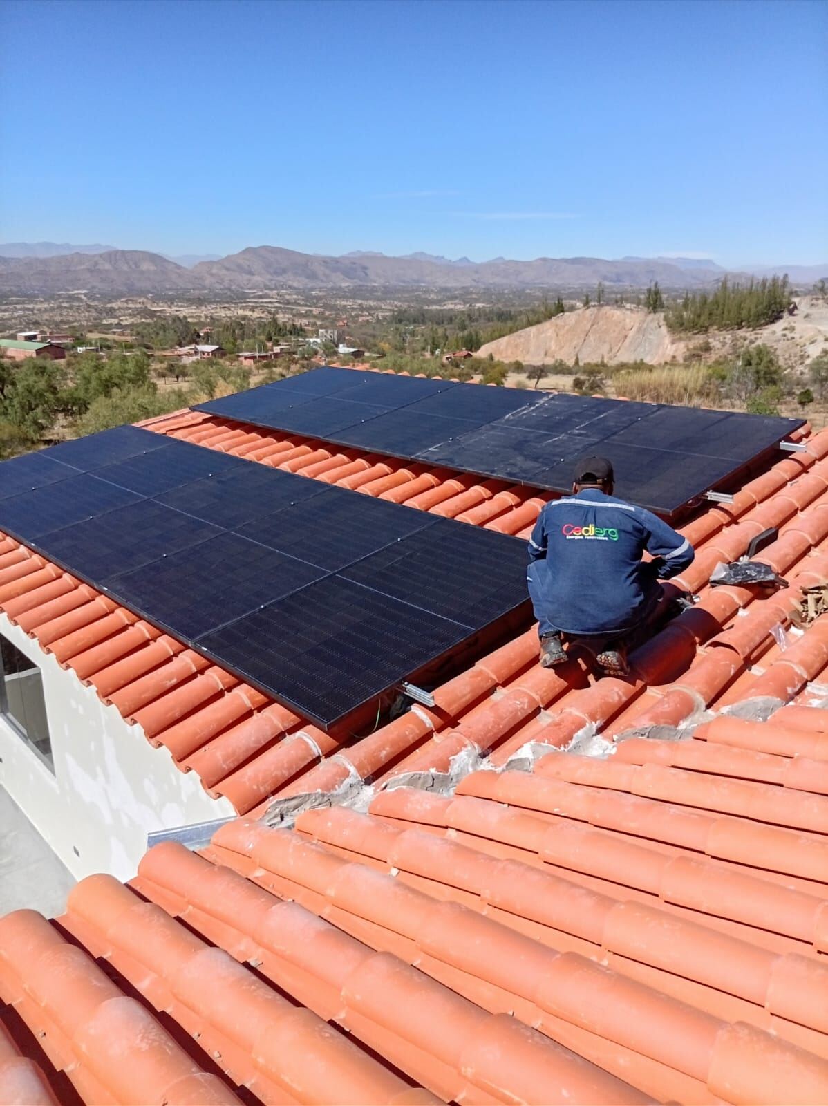 Técnico de CEDIERG instalando módulos sobre techo de teja